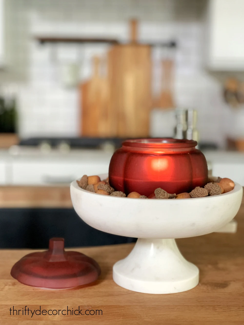 pumpkin candle on marble pedestal