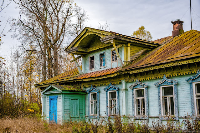 Деревянный дом с резьбой осенью