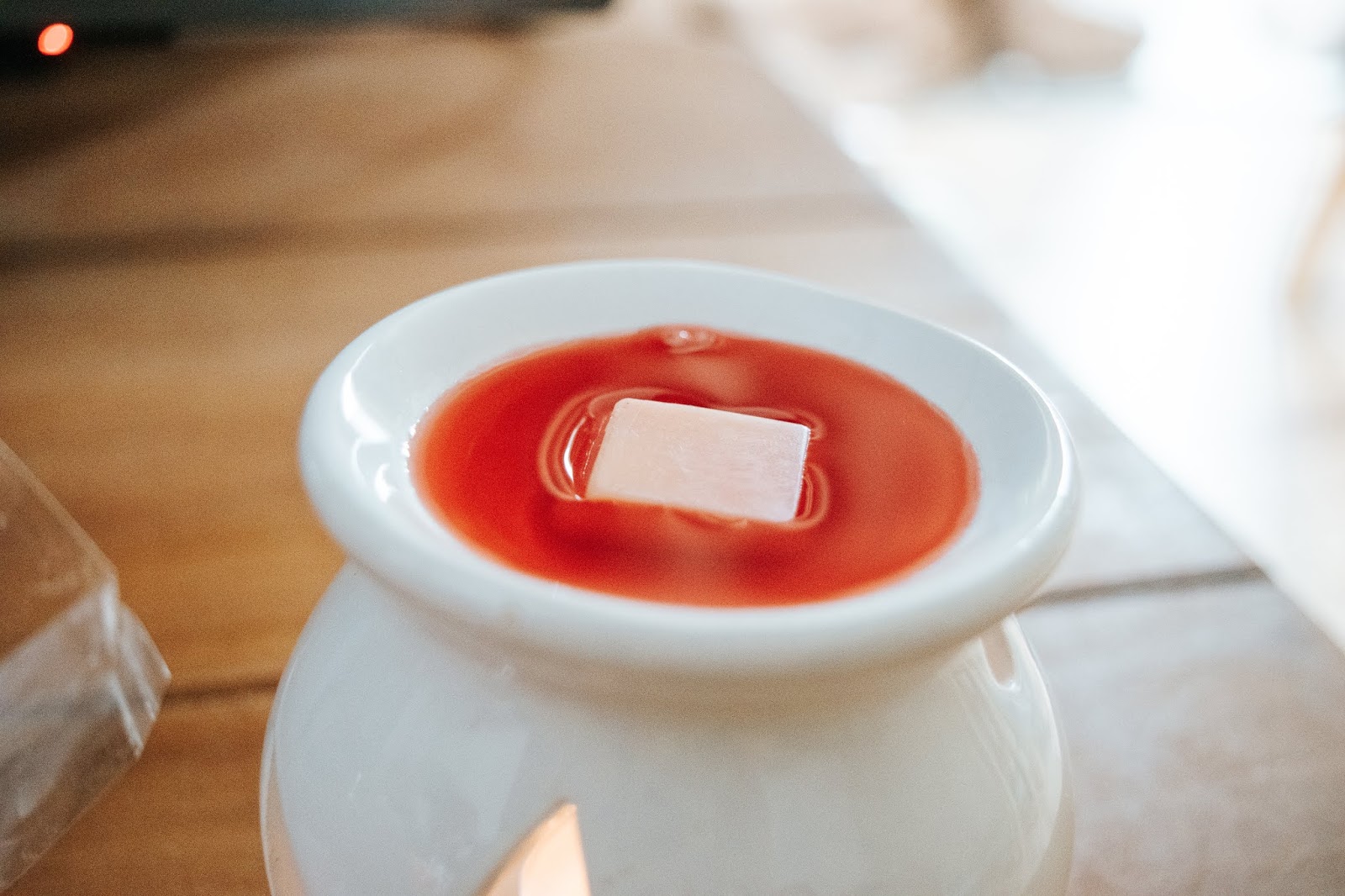 Red and orange wax melt melting in a wax melt burner.