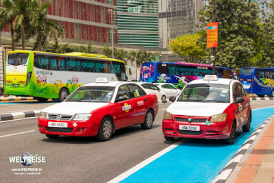 Kunterbunt! Taxis und Reisebusse in Kuala Lumpur.