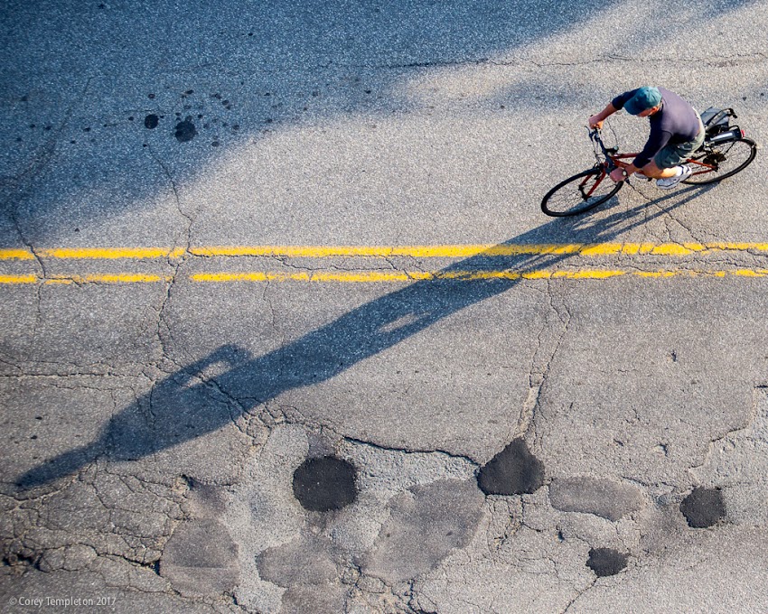 Portland, Maine USA June 2017 photo by Corey Templeton. A cyclist and their shadow heading down Pearl Street in the Old Port.