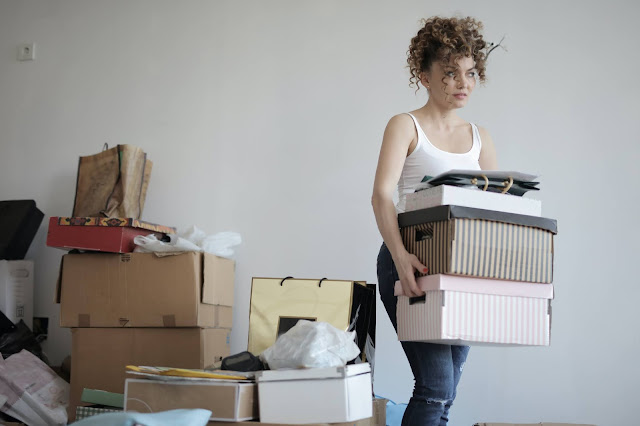 A girl packing up her stuff in bags and boxes.