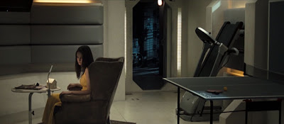 dark haired woman sitting in an armchair in a recreation room