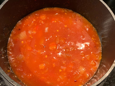 spicy tomato sauce with beef stock in a saucepan