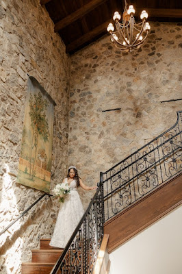 bride in white gown walking down bella collina staircase with white bridal bouquet