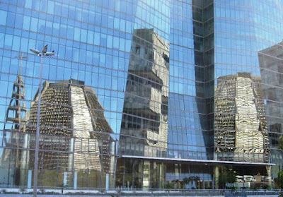 Distorted reflections of buildings in office block windows