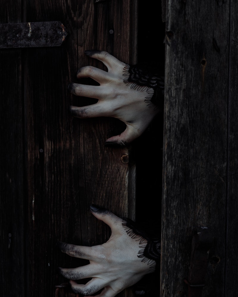 Halloween door decorated with zombie hands