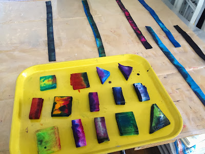 an old cafeteria tray filled with a dozen or so folded and dyed papers