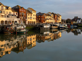 Photo of reflections on the calm water in Maryport Harbour