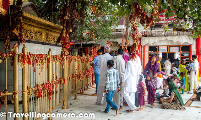 Chintpurni is a place of pilgrimage in Himalayan State of India. Chintpurni is located in Una region of Himachal Pradesh state, surrounded by the western Himalaya in the north and east in the smaller Shiwalik (or Shivalik) range bordering the state of Punjab. Chintpurni is dedicated to the temple of Chinnamastika Devi or Chinnamasta Devi. Chhinnamasta or Chinnamastika temple is one of the 7 major and 51 total Shakti Peeths.This Photo Journey shares some of the photographs from a quick visit to Chintpurni while we were in Amb for an event. During one of the weekends last month, I had to visit Amb in Una for an event. After overnight journey in HRTC Volvo, I reached Amb at around 4:00 am. After taking some rest till 10 am, I had nothing to do as event had to start at 3:00 pm. Chintpurni Temple is 30 Kilometers form Amb and it takes around 1:15 hrs to reach there. So I thought of visiting Chintpurni Temple while it was drizzling outside...Above photograph shows devotees buying flowers at Chintpurni Market..Chintpurni Temple is dedicated to Mata Chintpurni Devi which is located in District Una of Himachal Pradesh. Mata Chintpurni Devi is also known as Mata Shri Chhinnamastika Devi. Devotees have been visiting this Shaktipeeth for centuries to pray at the lotus feet of Mata Shri Chhinnamastika DeviPost summers and during Monsoons, lot of folks from Punjab come to Chintpurni Temple. Many of them come on bicycles and others choose trackters, trucks etc... Many families plan it as a religious trip and some of them also spend holidays in surrounding hill stations like Dharmshala & Palampur.Above photograph shows a Grandmother with her granddaughter, walking towards temple of Mata Chintpurni.Many folks reach temple in this way... This is one of the ways to take blessings of Chintpurni Mata. People lie down, make a mark, get up and again lie down to measure next distance. Whole distance till Temple entry is covered like this only.  It is hard to believe for someone who see it first time, but it's true..Just next to the temple, there is a huge tree which is covered with lot of red colored cloths (Chunnis), Sehra and choodas... Newly married couples come here to present their sehra and chooda(a set of red bangels, especially used by newly married girls in India)... Folks who come to the temple with some wishes, they tie a red colored cloth on branches of this tree. Above photograph shows one of the newly married girl with a Sehra on left and Chooda on right...Lot of devotees from Punjab bring with them their worldly concerns and seek blessings from the Devi. It is believed that if you ask something from the Devi with a true heart, your wish will be granted. Apart from the holy shrine, the place is full of picturesque surroundings. Some very nice places for sight seeing, indoor and out door activities are situated in and around Chintpurni. Chintpurni is very well connected through roads and with good number of hotels... You can come here for religious visit, on a holiday or for both, you would enjoy your time there and should return with everlasting memories Mangoes are found in abundance around Chintpurni and some intersting mango products can be bought from shops in Chintpurni MarketHindu pilgrimage and marriage records were also used to be kept at this holy place. The Genealogical Society (GSU) of Utah, USA has microfilmed Hindu pilgrimage records for Haridwar and several other Hindu pilgrimage centers. Priests (pandits) located at each site would record the name, date, home-town and purpose of visit for each pilgrim. These records were grouped according to family and ancestral home. The holdings by GSU include Haridwar, Kurukshetra, Pehowa, Chintpurni, Jawalapur and JawalamukhDevotees usually bring offerings for the Devi. Sweets, Rice kheer, batasha, coconut, chunni, dhwaja (red-colored flag), flowers and ghee are some of the offerings that devotees bring. Many people still prefer to bring prasad from home, but different kinds of stuff is available in market. Above photograph shows back side of main temple where people sit and prey to the godess.Photography session after mundan Sanskar at Chintpurni Temple, Una, Himachal PradeshMany families come to Chintpurni Temple for Mundan Sanskar where head of children is shaved with some poojan. There is a specific section in Temple campus, where all these Poojan Sanskars are donShehnai Team @ Chintpurni Temple, Una, Himachal Pradesh, INDIA ...In the center of the Temple is the temple garbha griha. The image of Mata Chintpurni Devi is installed here in the form of a round stone. People queue up for a darshan of the Devi and make their prayers and offerings. The view of the Chintpurni town and the far flung scenic contours is enjoyable from the back-yard of the temple.