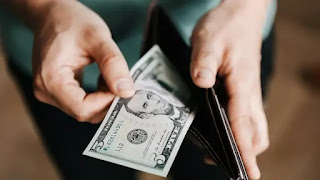 Man putting cash into his wallet after receiving salary