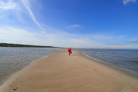 A person walking on a sand bank on sunny day. 