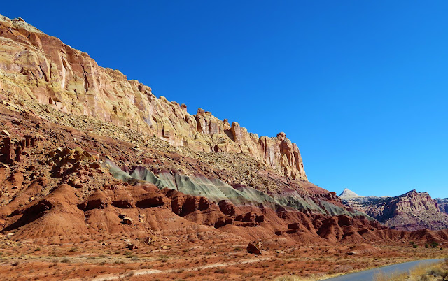 A long cliff made up of different colored layers.