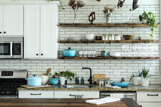 A kitchen with white subway tile and open shelving