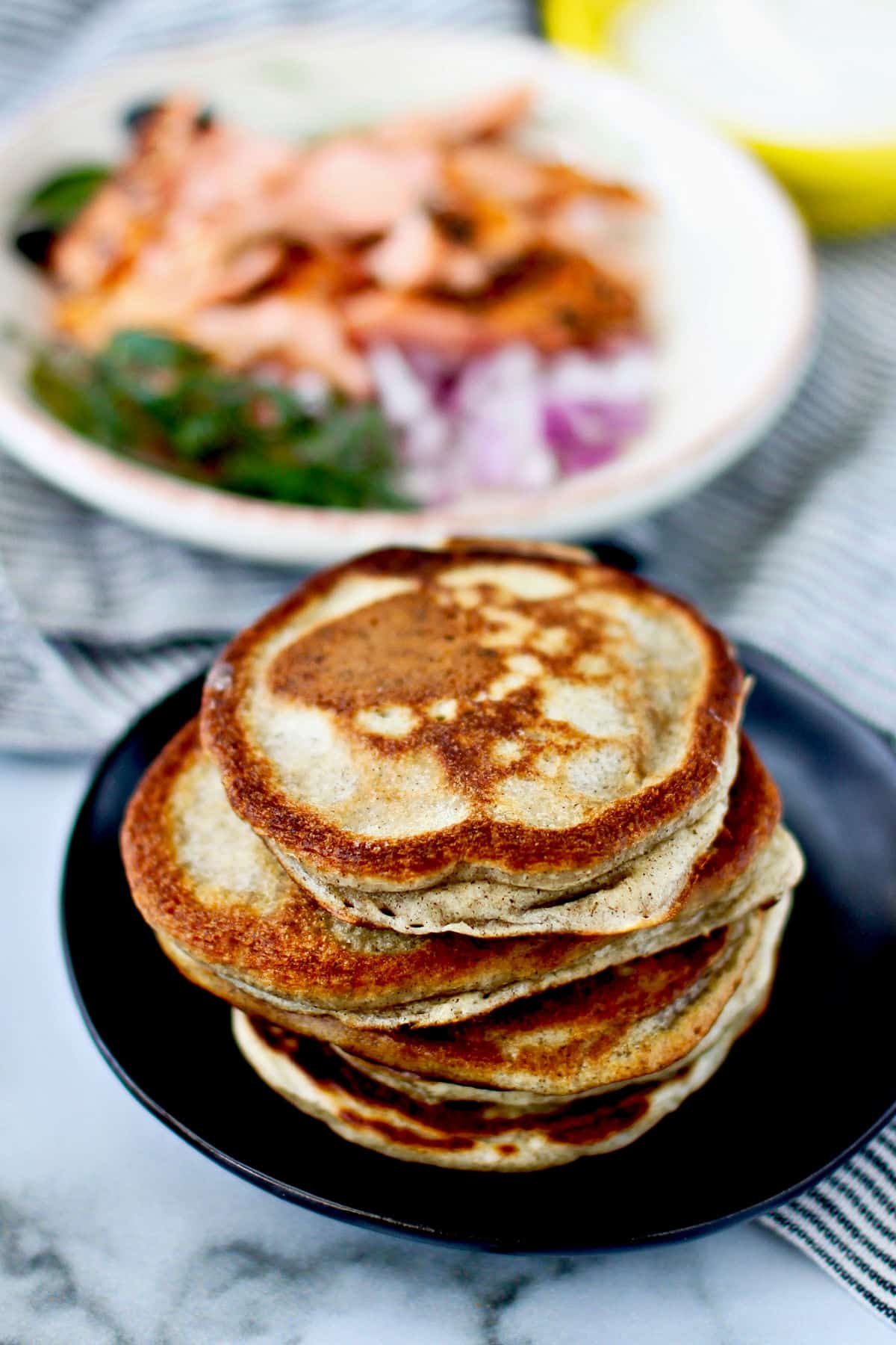 Sourdough French-Style Blini displayed with a plate of salmon and toppings.