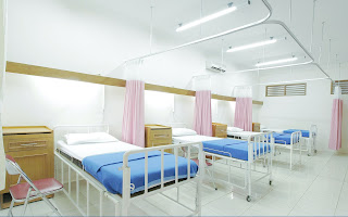 A photo of empty hospital beds in a single room.