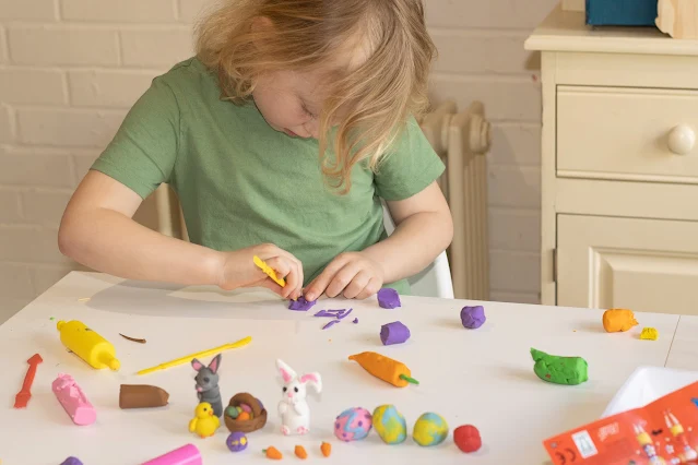 cutting and shaping some purple Plasticine using the tools included in the sets