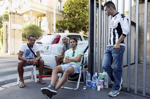 Emanuele Pesoli sits on a chair after chaining himself outside of the FIGC headquarters