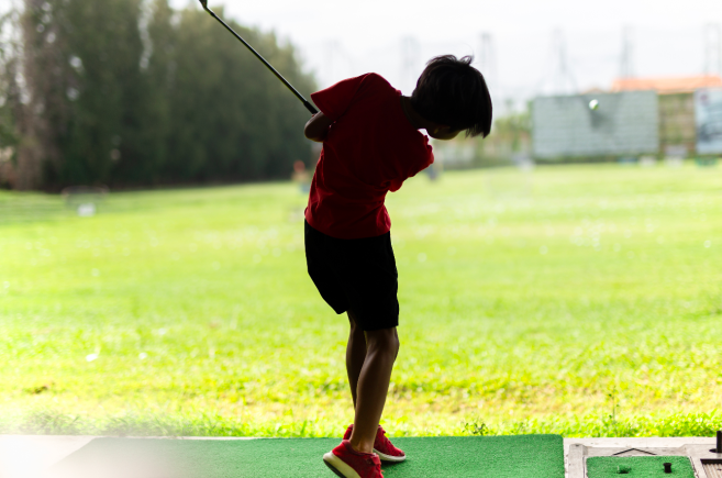boy swinging a golf club