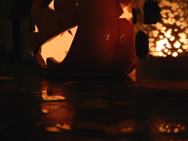 a pumpkin and ghost candle holder.
