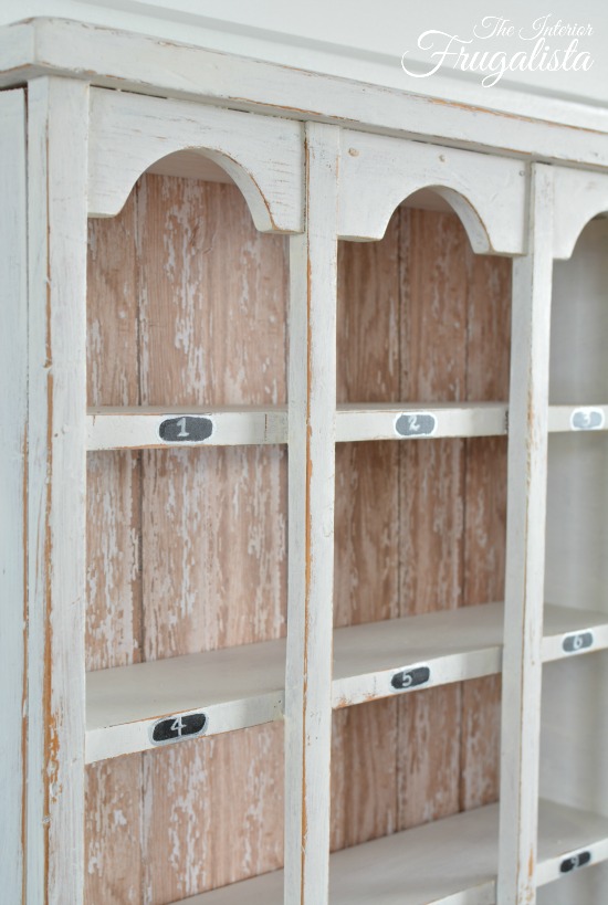 A 12-slot vintage cubby upcycled with barnwood scrapbook paper in farmhouse style and decorated for Valentine's Day with dollar store finds.