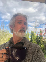 John looking archly over a giant tea mug