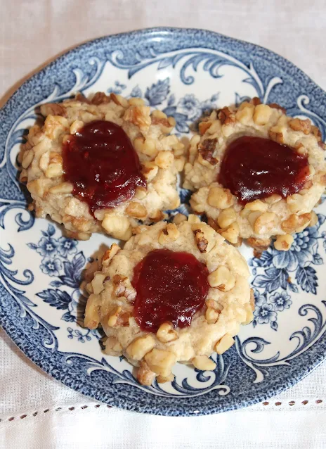 Close-up of finished thumbprint cookies filled with raspberry jam.