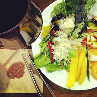 A plate of food, glass of wine, chopsticks, and a napkin from Sung's Buffet in Cheongju, South Korea.