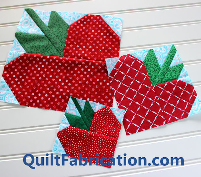 three different sizes of red strawberry quilt blocks