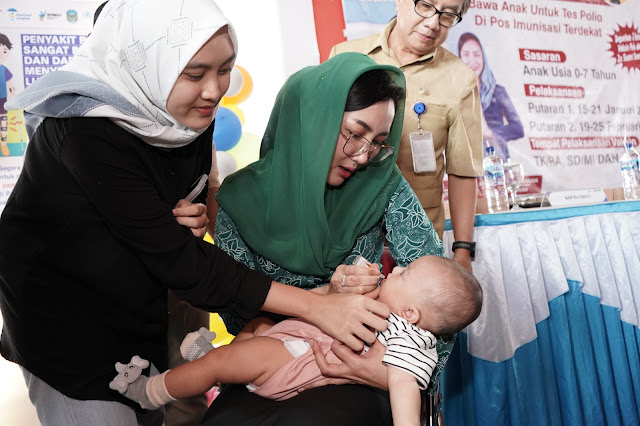 Pj Ketua TP PKK Kabupaten Nganjuk, Ny Eka Haryati Taruna, saat memberikan tetes vaksin polio pada salah satu balita di Balai Desa Batembat, Kecamatan Pace, Senin 15 Januari 2024