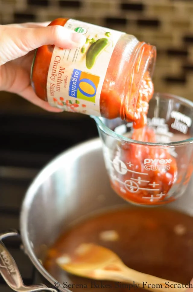 Salsa being poured into a liquid measuring cup.