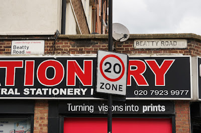 A section of wall with two signs for Beatty Road, each in a different but quite modern style.