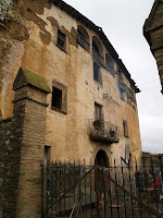 La façana principal amb el portal d'arc rodó, un balcó i l'eixida de la planta sota teulada