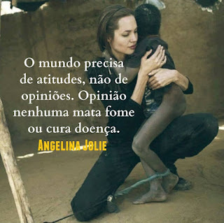 Foto. Angelina Jolie em um pátio de chão de areia, está agachada com o joelho direito apoiado no chão e sobre a coxa da outra perna dobrada e aérea, apoia um garoto magérrimo de pele negra com aspecto ressecado e sujo, o corpo nu parcialmente coberto por camiseta escura, bem maior que ele. Com a cabeça voltada para trás ele abraça a protetora que retribui ternamente espalmando a mão direita abaixo do ombro esquerdo do menino e o braço esquerdo enlaça-o e a mão em concha circunda a frágil cintura. O garoto tem o tornozelo esquerdo amarrado por um tecido azul retorcido, preso a uma corda fortemente estirada em uma estaca de pau. Angelina é uma mulher de pele alva, magra, rosto oval, cabelos castanhos escuros lisos e compridos presos para trás por uma fina tiara preta, sobrancelhas curtas, olhos fechados, nariz médio levemente arrebitado e lábios grossos; ela usa um macacão e botinas pretos. Ao fundo, um muro com reboco rachado e em uma parte à direita, no alto, quebrado.  Sobreposto à foto escrito em letras brancas, lê-se: O mundo precisa de atitudes, não de opiniões. Opinião nenhuma mata fome ou cura doença. Angelina Jolie.