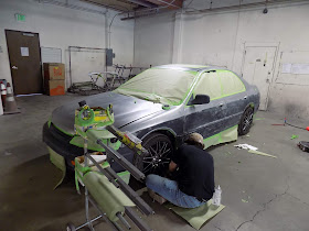 Almost Everything Auto Body technician masking a car prior to paint.