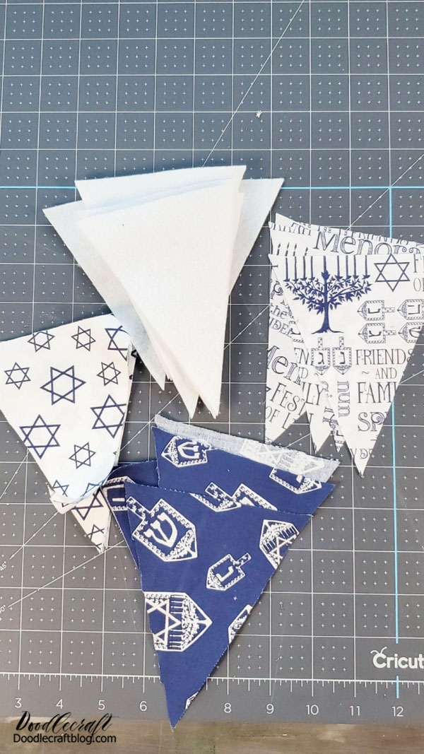 Use the cutting mat and rotary cutter to cut isosceles triangles of fabric and felt.   You will need 2 pieces of fabric and 1 piece of felt for each triangle bunting.