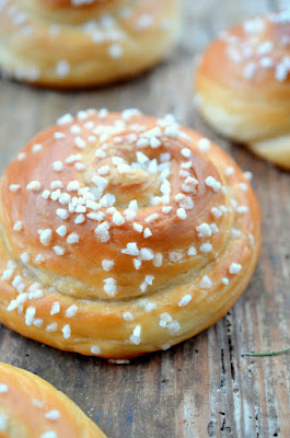 Goldgelb gebackene Schnecken aus Hefeteig mit Hagelzucker bestreut.