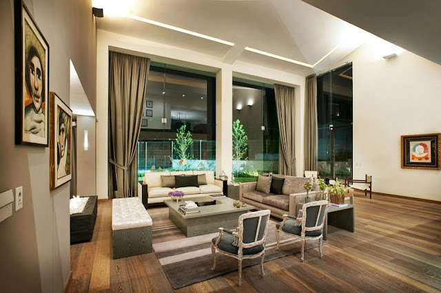 Luxury modern living room with floor to ceiling windows at night