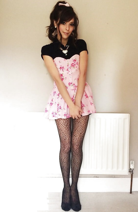 Beautiful crossdresser in floral mini dress, black pantyhose and black flats