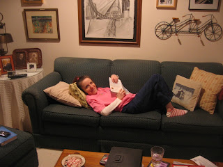 Me, lying on my parents' couch reading, with only one leg visible.