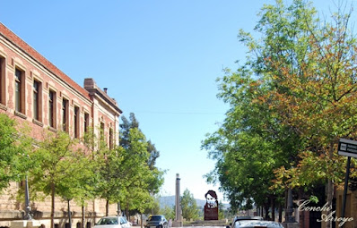 Imagen de la Escuela Industrial de Alcoy a la izquierda, el barrio del Tossal a la derecha, y al fondo en linea recta con el puente del viaducto escultura homenajes a Ovidi Montllor