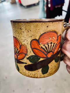 A close up of a flower on a vintage mug