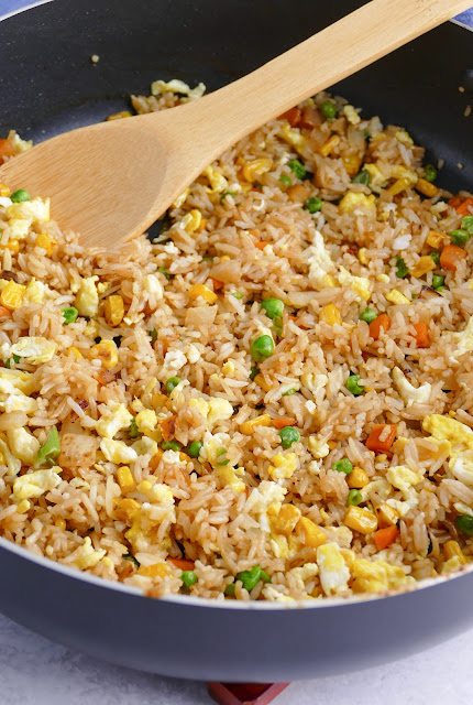 Fried Rice in a pan with a wooden spoon.