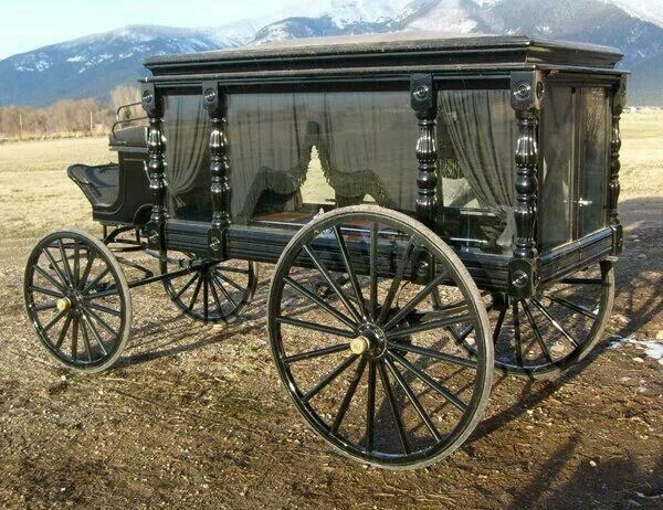 Carroza funeraria tirado por caballos con ataud negro victoriano en el siglo XIX.