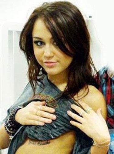 miley cyrus tattoo finger cross. Miley also has multiple body