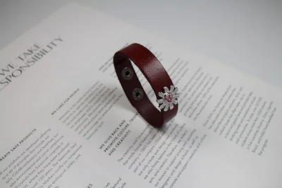 A Brown Leather Bracelet Lying on White Paper