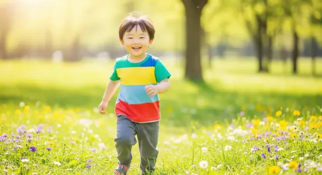 꽃이 만발한 푸른 잔디밭을 웃으며 뛰어가는 아이