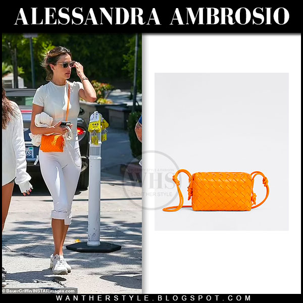 Alessandra Ambrosio in white leggings with orange crossbody bag in LA on July 26