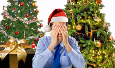 depressed man by christmas tree and presents