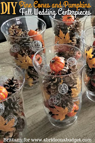 If you're planning a fall wedding, you need to make these DIY Pine Cones And Pumpkins Fall Wedding Centerpieces. Find out how on www.abrideonabudget.com.